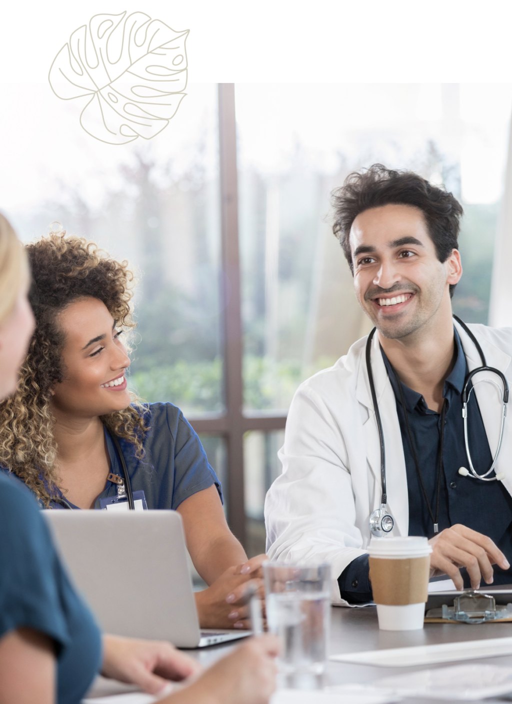 Male doctor smiling talking to two nurses